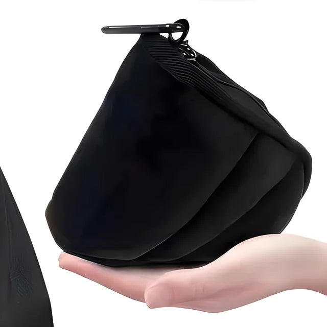 The travel pouch with its carabiner clip resting in an open hand